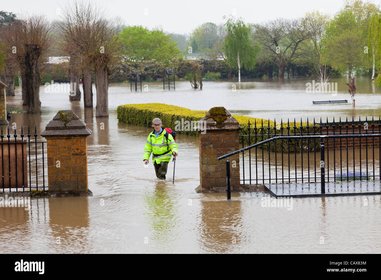 Tewkesbury, Gloucestershire. 01 Mai 2012. Ein Mann in Watvögel nimmt einen Spaziergang auf der Uferpromenade neben dem überfluteten Fluss Avon bei Tewkesbury. Stockfoto