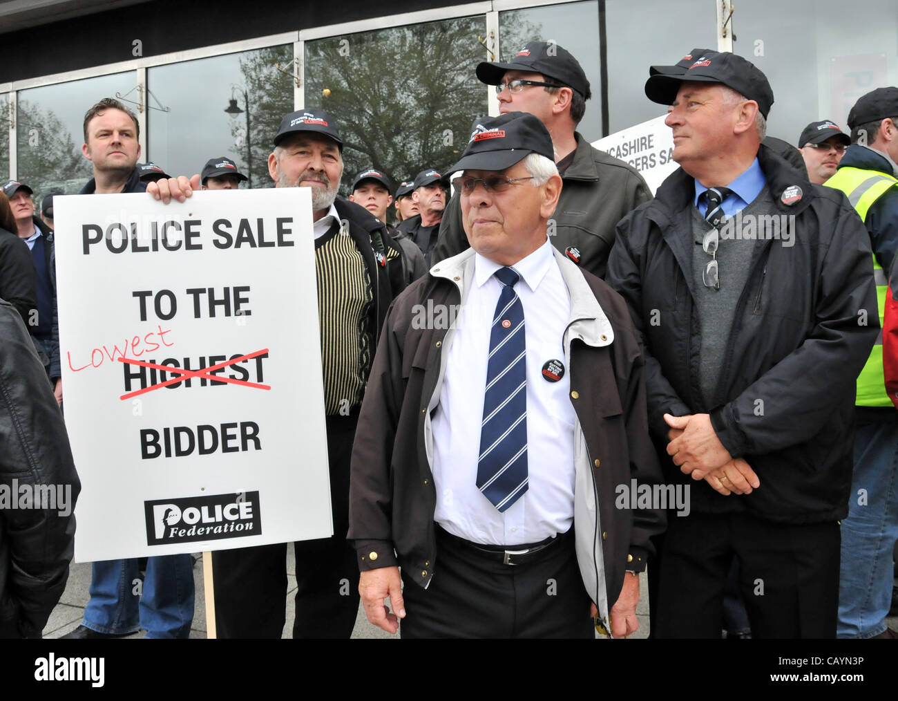Off Duty Polizisten halten eine Banner mit dem Slogan "Polizei Verkauf an den günstigsten Bieter", wie sie gegen Kürzungen im Dienst protestieren. Donnerstag, 10. Mai 2012. Millbank, London, UK. Stockfoto