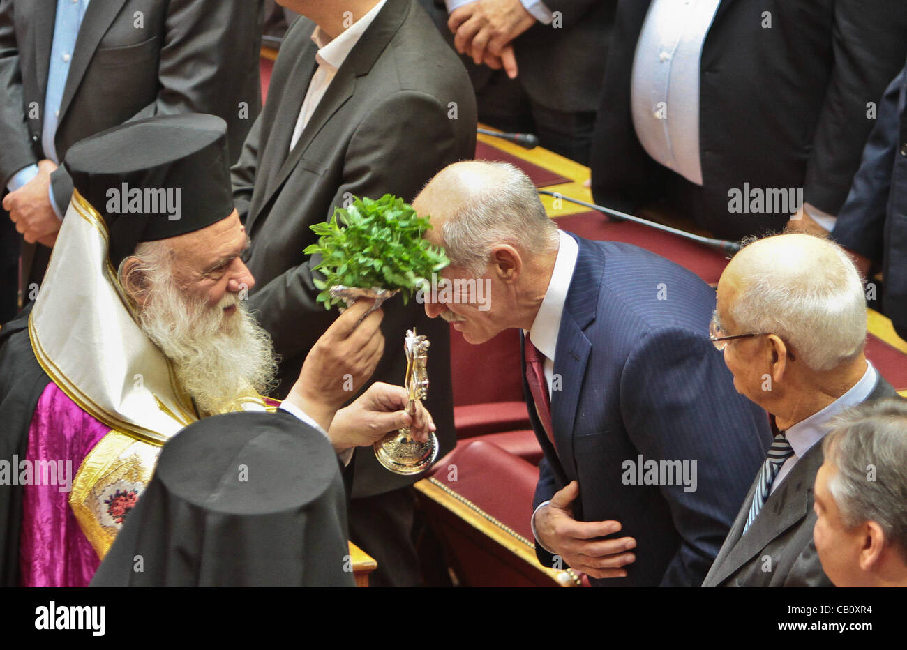 17. Mai 2012 - Athen, Griechenland - ehemalige Führer der griechischen sozialistischen Partei (PASOK) und Ministerpräsident George Papandreou wird mit heiligem Wasser geheiligt durch Hieronymus von Griechenland und Mitglieder des Heiligen Synod.  Parteiführer und Mitglieder der griechischen Regierung nehmen den Amtseid in der griechisch-P Stockfoto