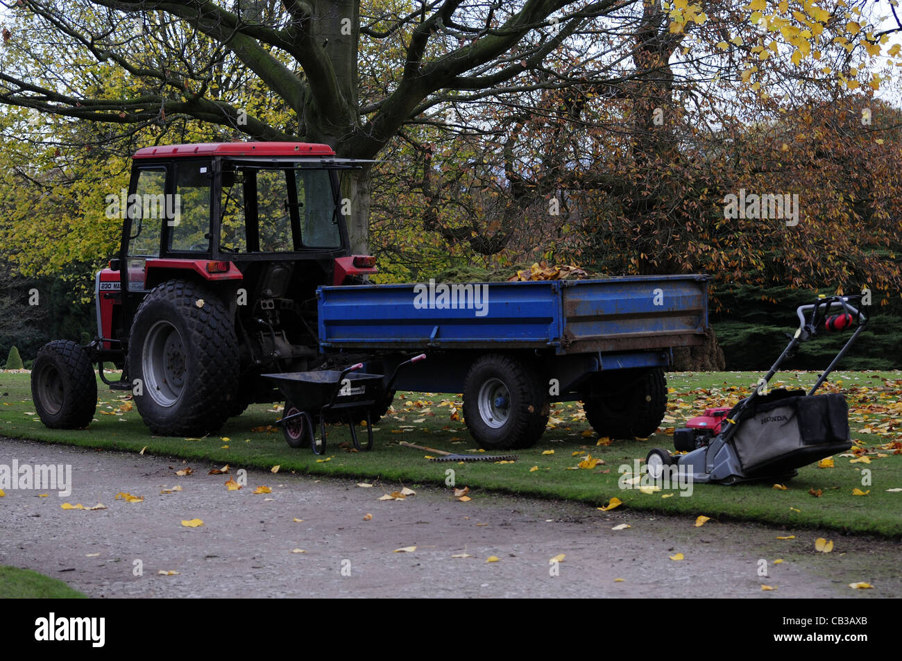 Massey Ferguson Traktor mit Anhänger und Rasenmäher dahinter