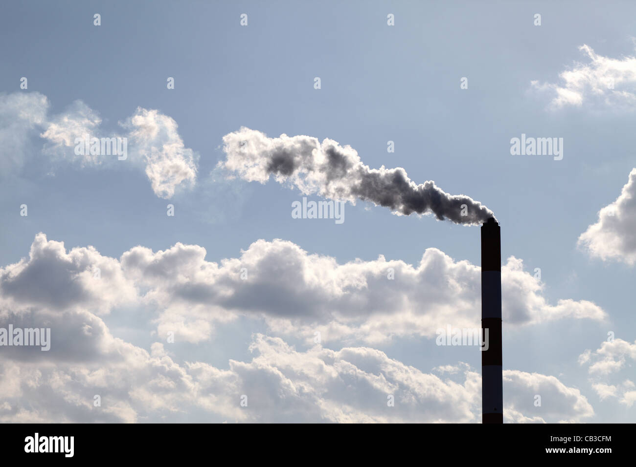 Industrielle Schornstein mit Rauchwolken über blauen Himmel Stockfoto