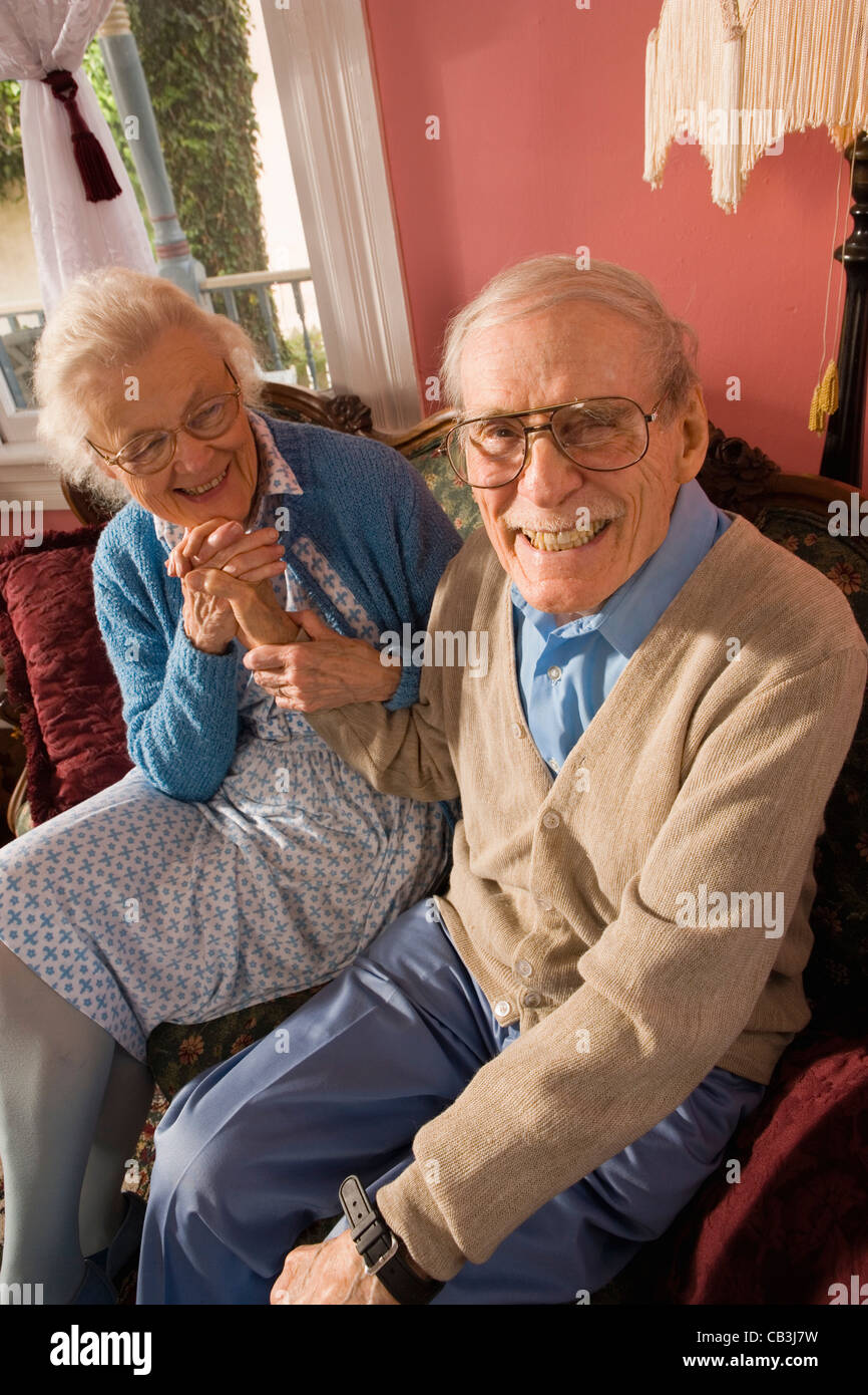 Liebevolle älteres Paar sitzt auf dem Sofa im Wohnzimmer Stockfoto