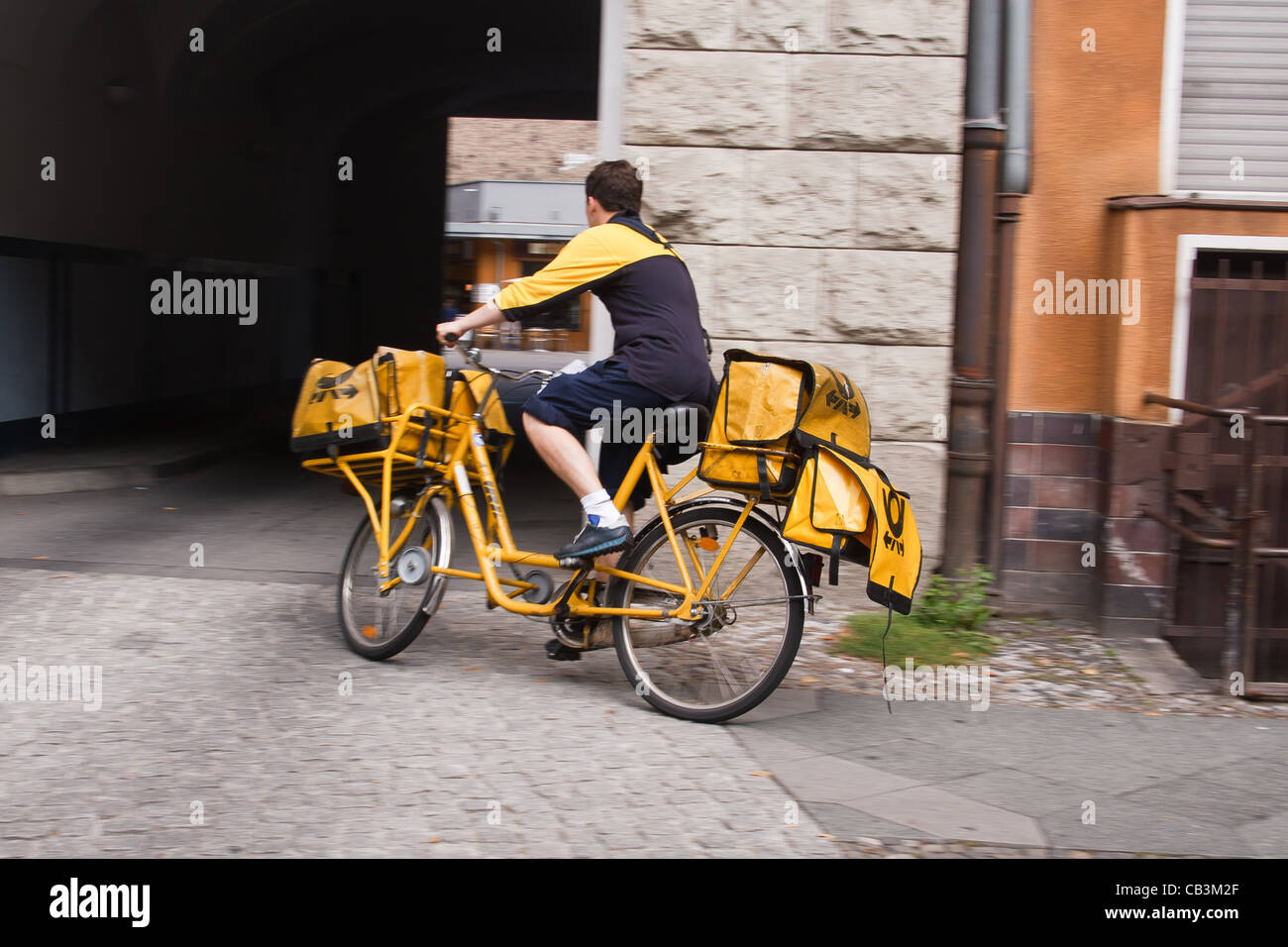 Deutsche Post Postbote auf gelben Fahrrad. Berlin