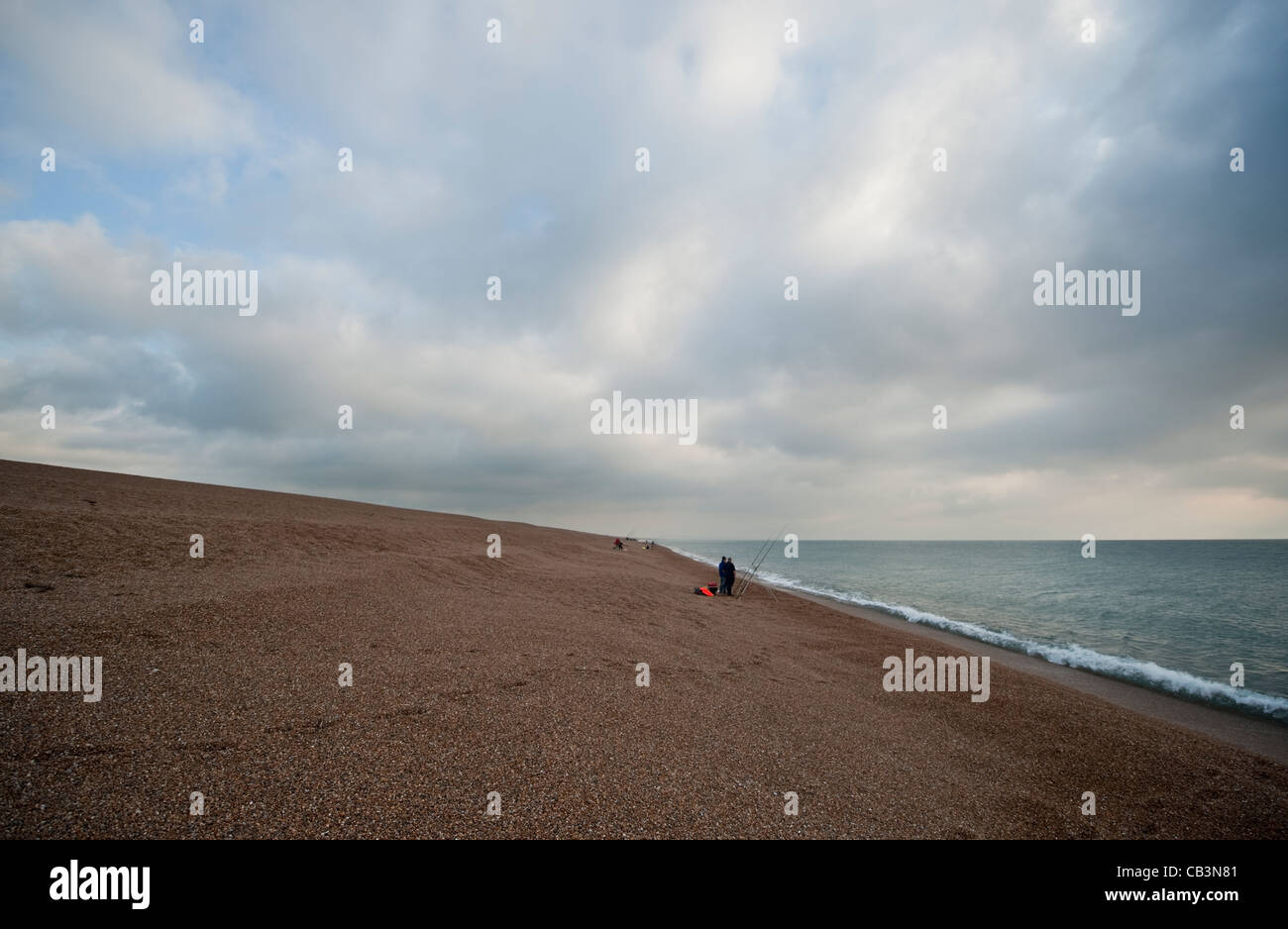 Angeln im Meer unter Herbst Himmel aus Chesil Beach in der Nähe von Abbotsbury in Dorset, eine 29 km lange Barriere Kiesstrand an der Südküste Stockfoto