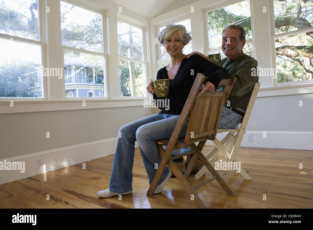Porträt des reifes paar drinnen sitzen renoviertes Haus Stockfoto