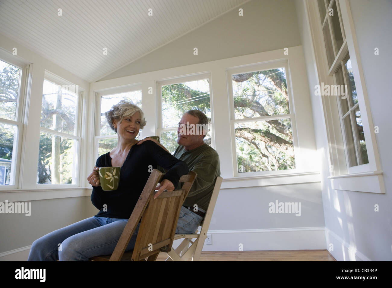 Porträt des reifes paar drinnen sitzen renoviertes Haus Stockfoto