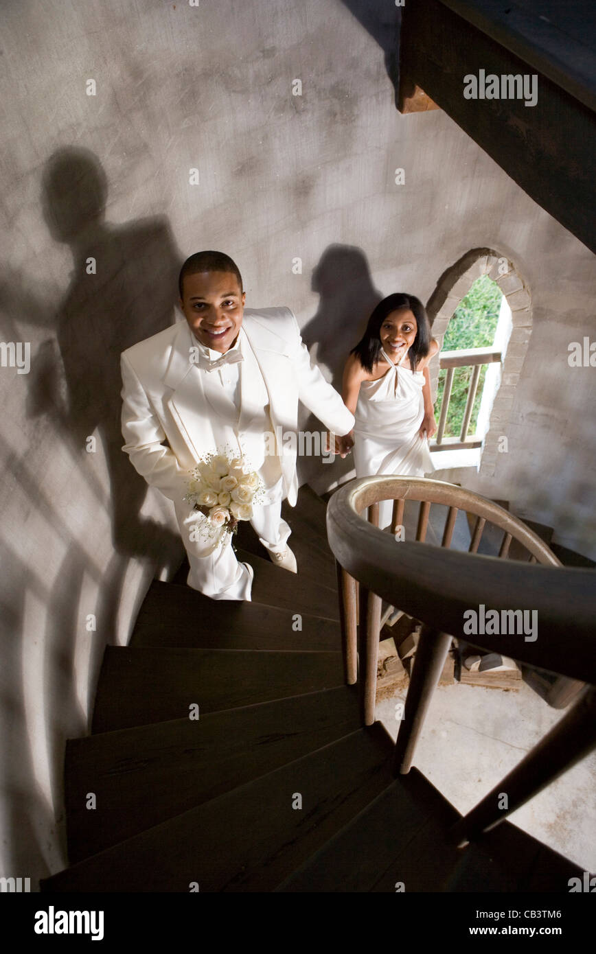 Eine Braut und Bräutigam in weiß eine Wendeltreppe hinauf Stockfoto
