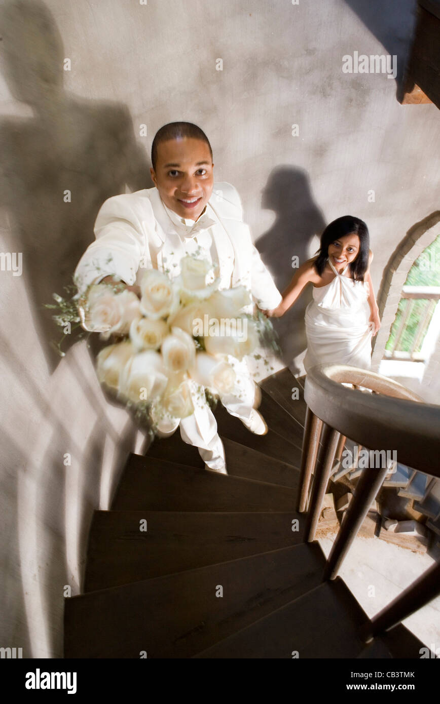 Eine Braut und Bräutigam in weiß eine Wendeltreppe hinauf Stockfoto