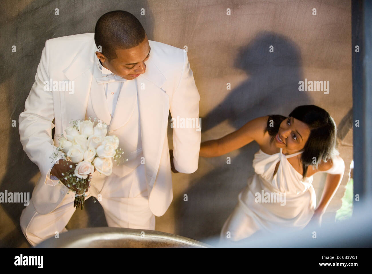 Junge Braut und Bräutigam Wendeltreppe aufsteigend Stockfoto