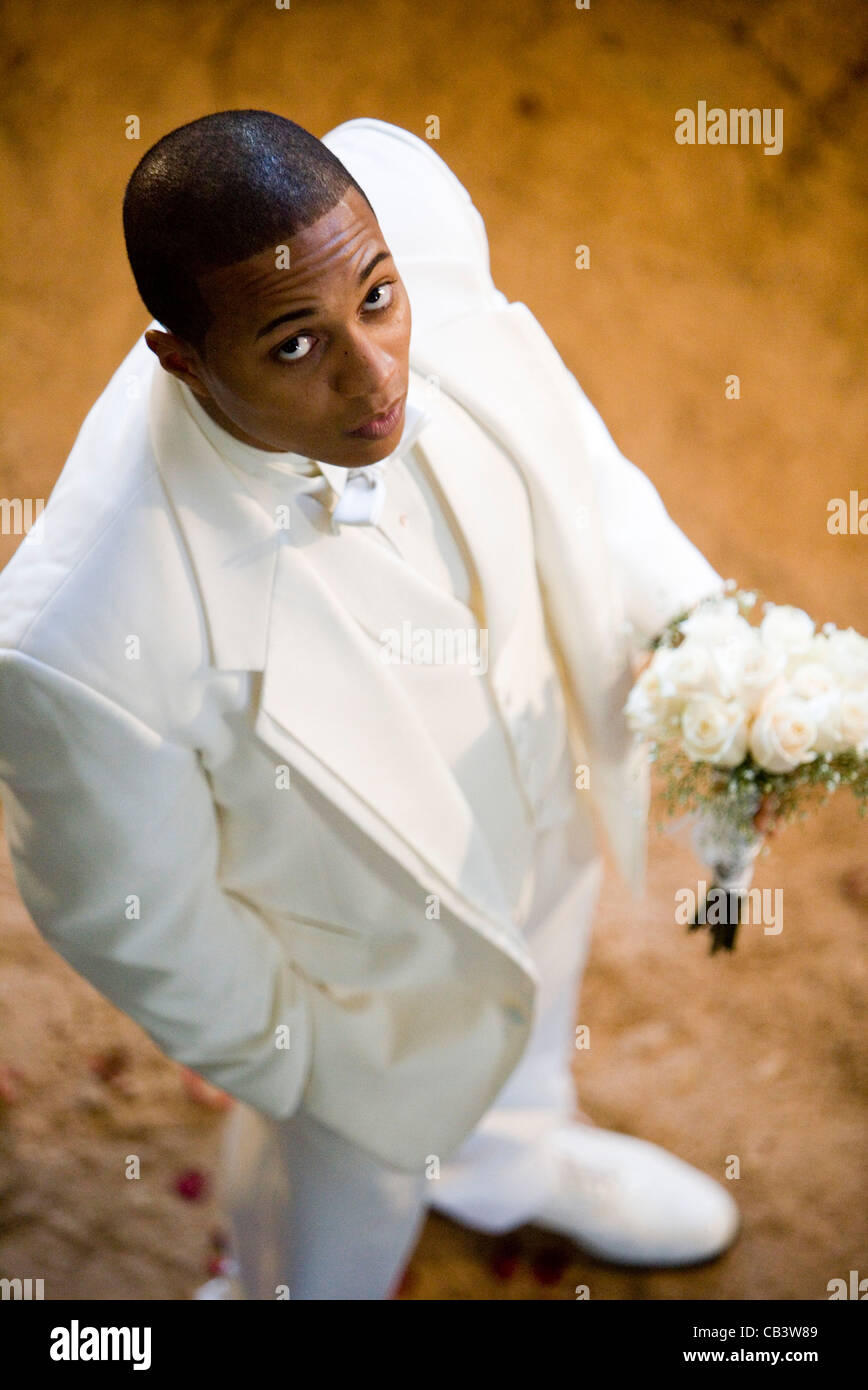 Erhöhten Blick auf einen Bräutigam in einen weißen Smoking hält einen Strauß weiße Rosen Stockfoto