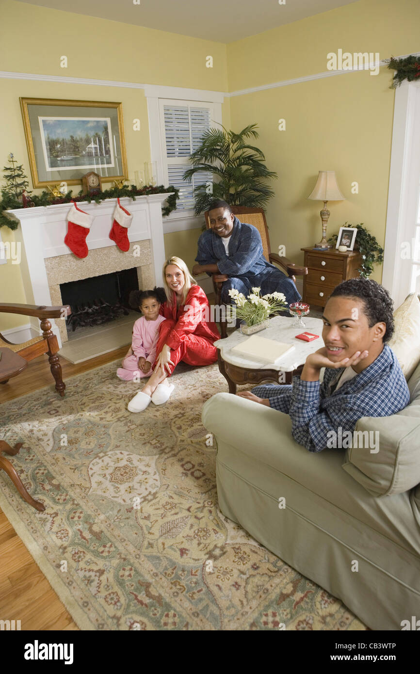 Familie im Pyjama im Wohnzimmer sitzen dekoriert für Weihnachten Stockfoto