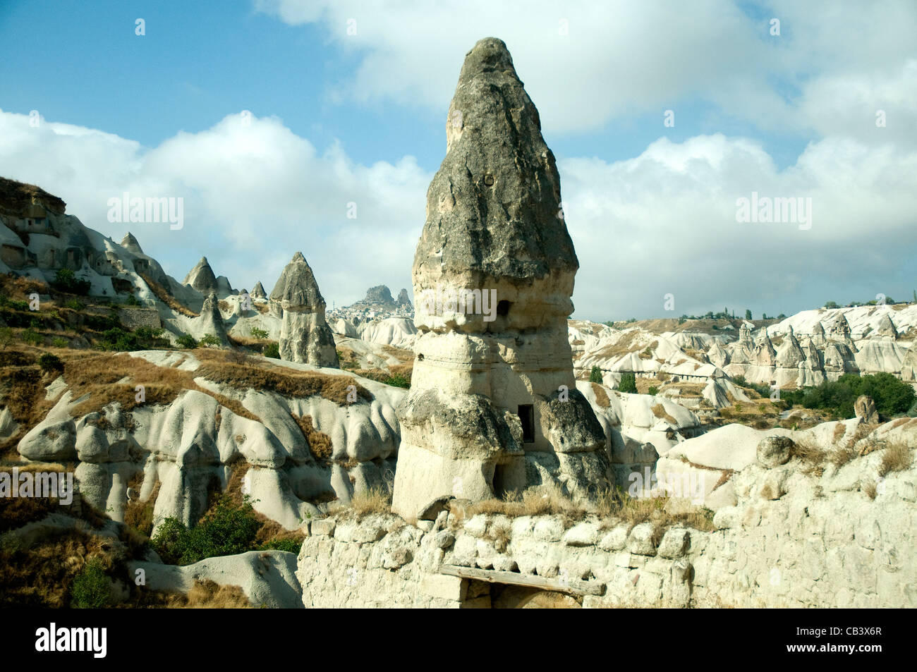 Hohe konische Felsen bieten Höhlenwohnungen in Cappadocia bizarre vulkanisch geformten Landschaft Stockfoto