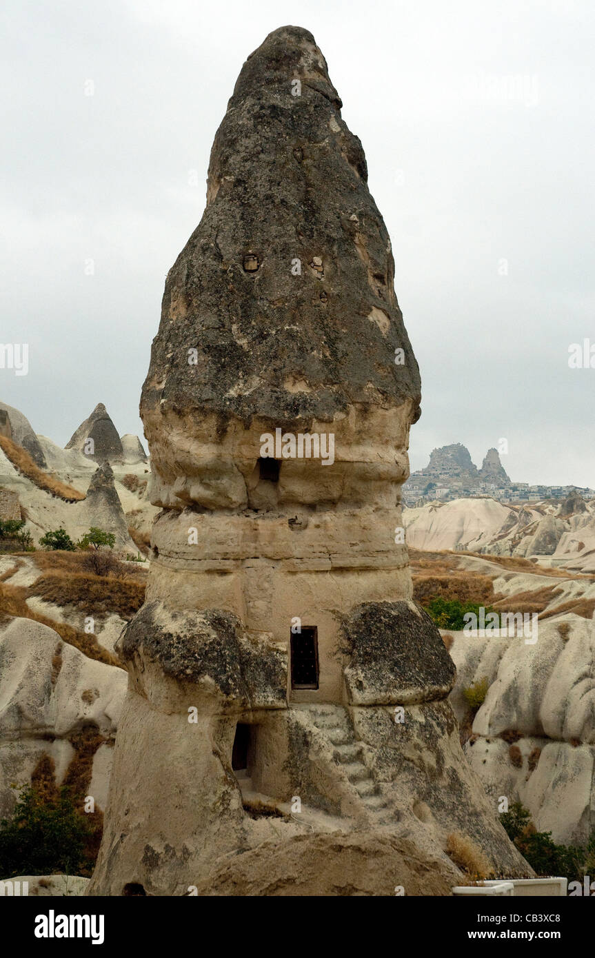 Hohe konische Felsen bieten Höhlenwohnungen in Cappadocia bizarre vulkanisch geformten Landschaft Stockfoto