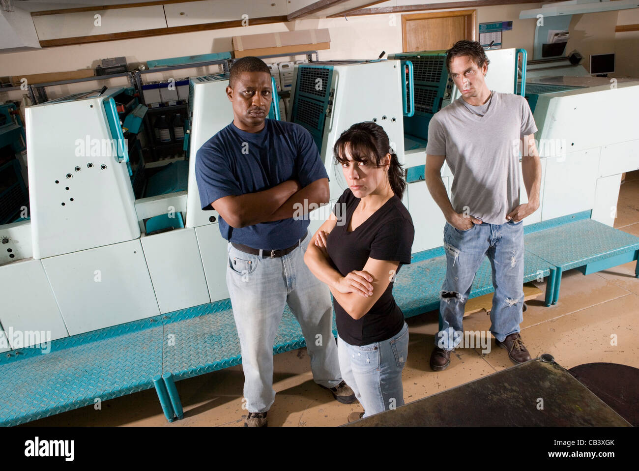 Porträt der Arbeiter neben einer Druckmaschine Stockfoto