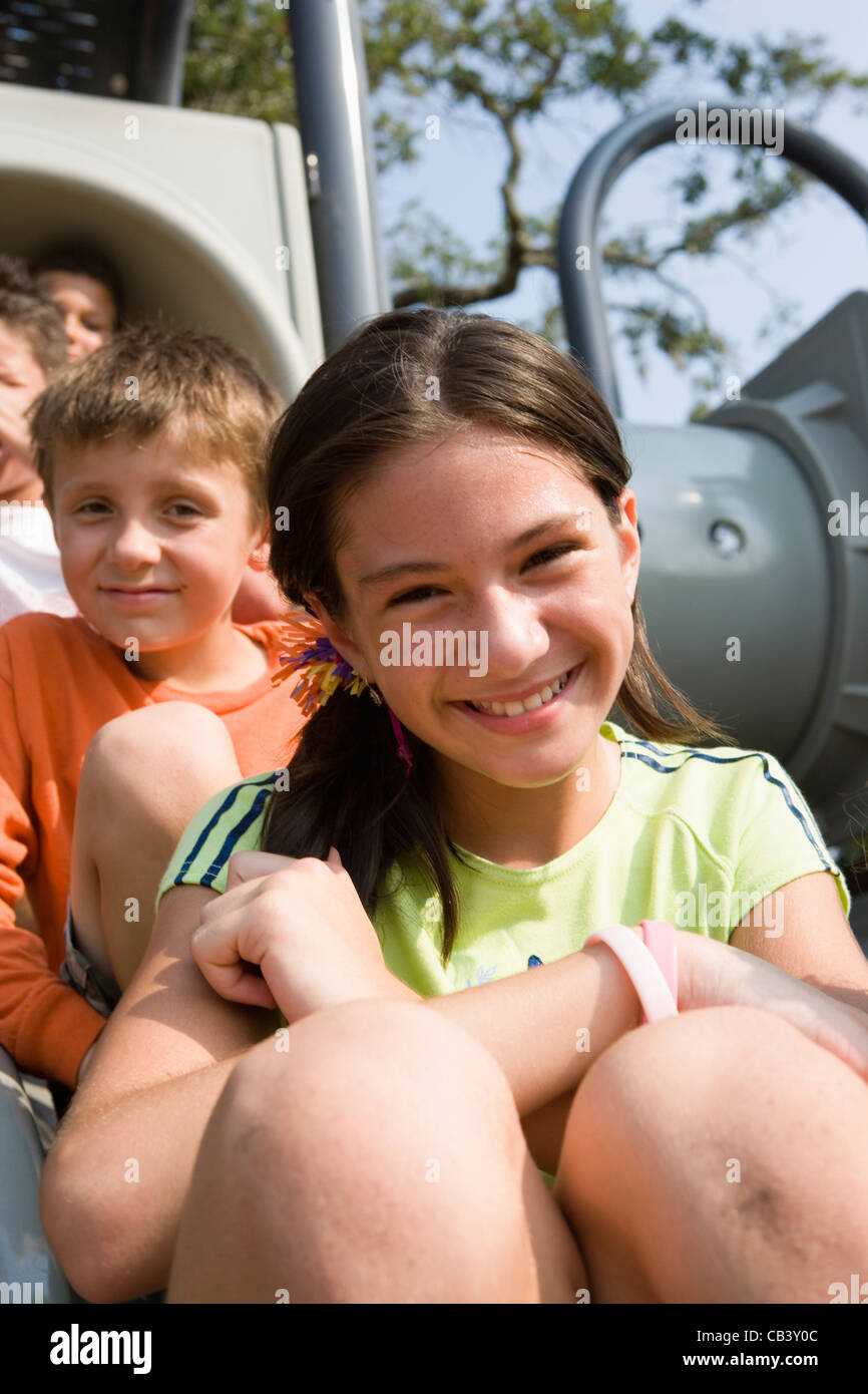 Nahaufnahme des Lachens Kinder sitzen auf einer Folie auf einem Spielplatz Stockfoto