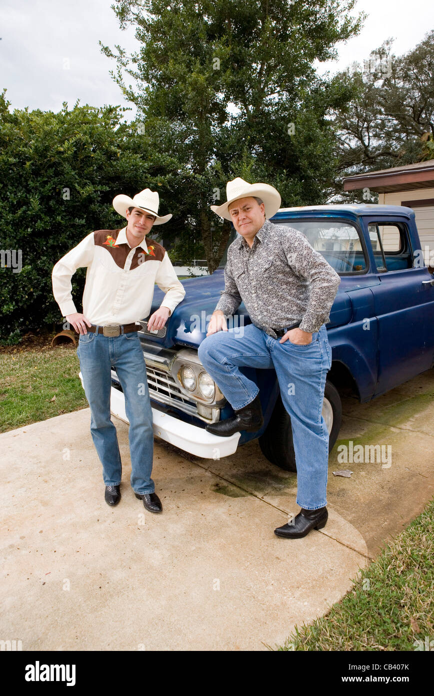 Porträt von Tex-Mex-Vater und Sohn durch einen Pick-up-Truck vor Haus Stockfoto