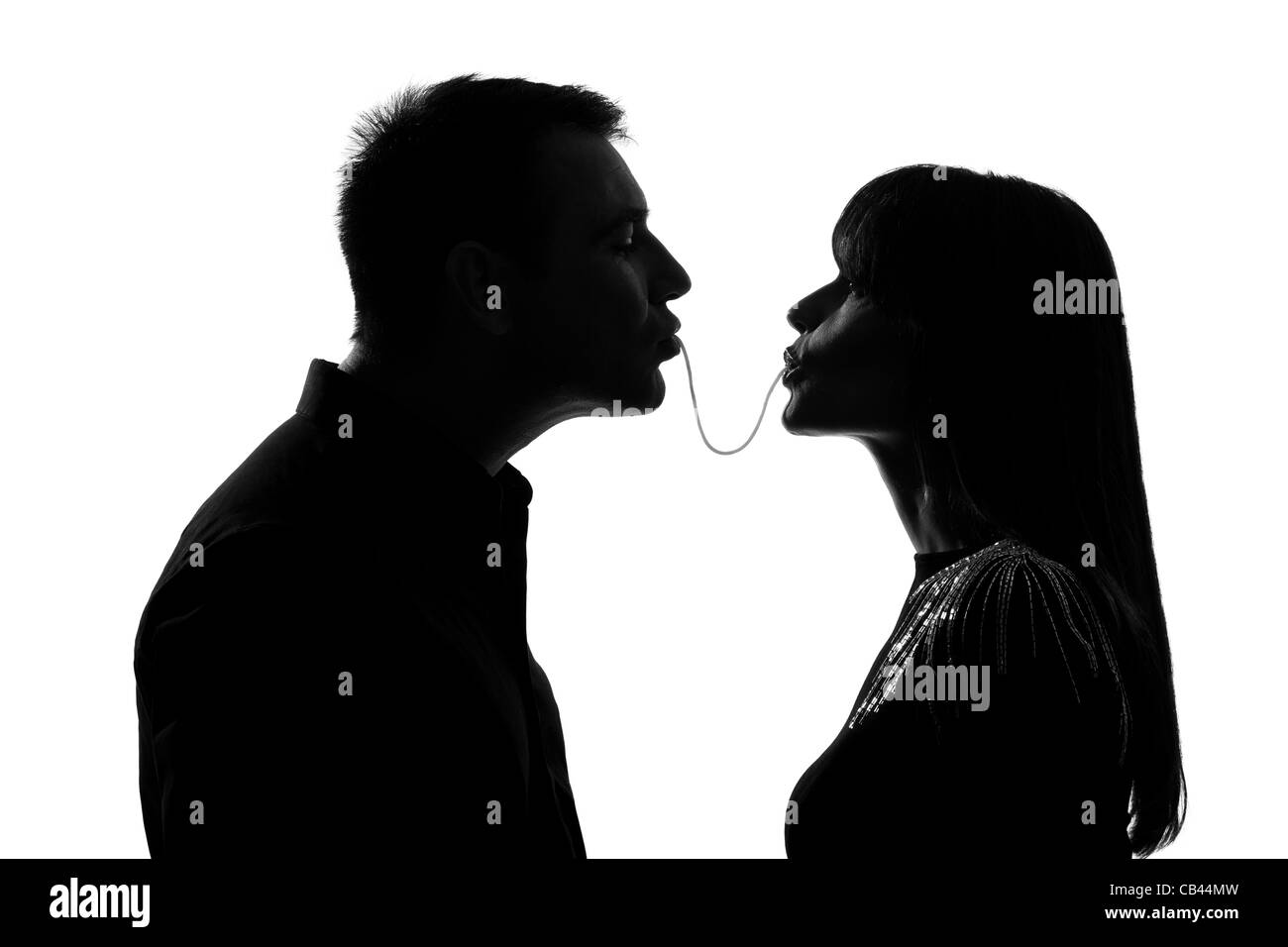 eine kaukasische paar Mann und Frau die gleichen Spaghetti zu essen, Studio Silhouette isoliert auf weißem Hintergrund Stockfoto