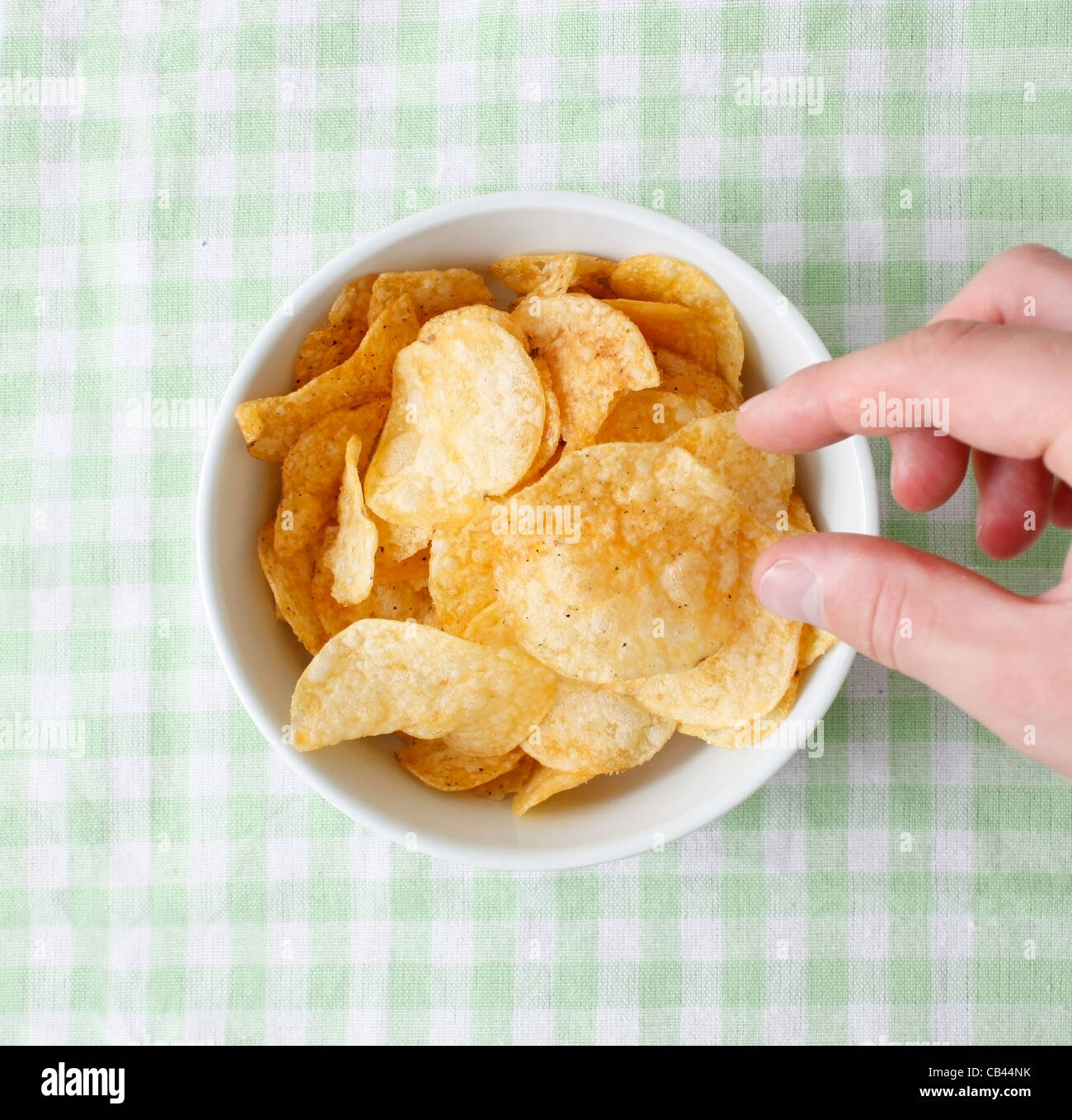 Naschen aus der Kartoffel-Chips-Schüssel Stockfoto