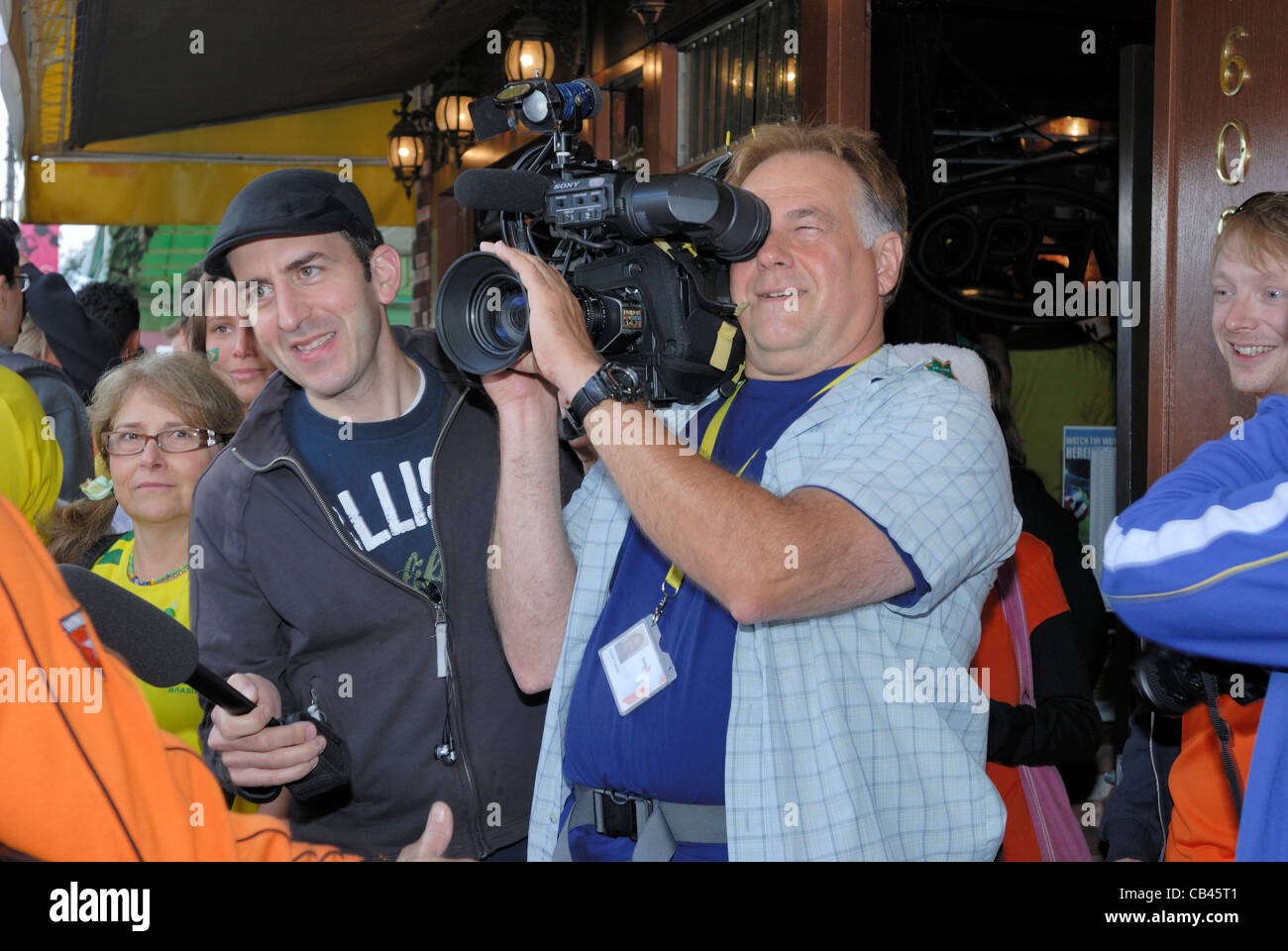 News Reporter Videoing ein fest auf den Straßen der Commercial Drive, Vancouver Stockfoto
