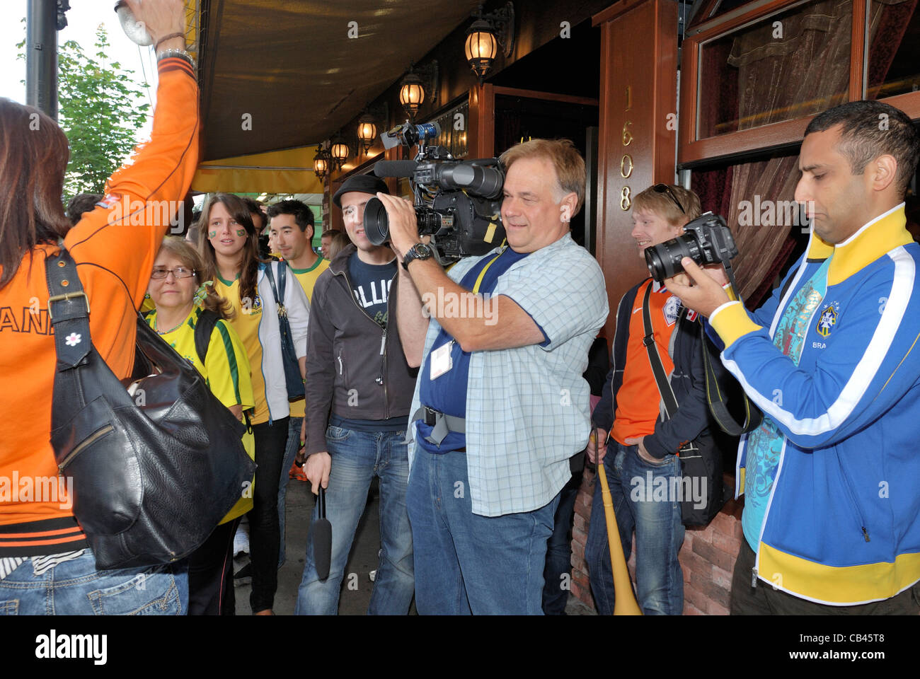 News Reporter Videoing ein fest auf den Straßen der Commercial Drive, Vancouver Stockfoto