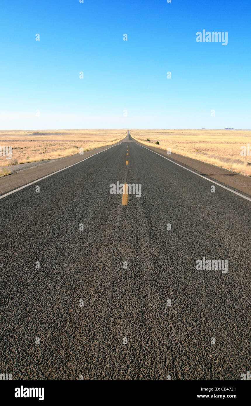 Autobahn 180 im nördlichen Arizona schneidet quer über die Wiesen bis zum Horizont unter blauem Himmel Stockfoto