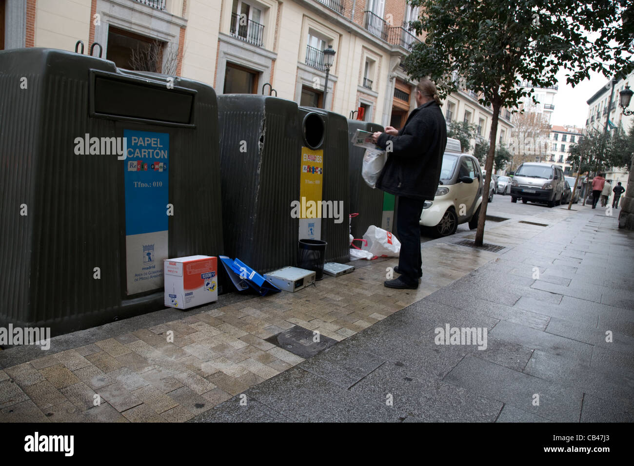 Menschen werfen Müll in große Recycling-Behälter-Madrid Stockfoto
