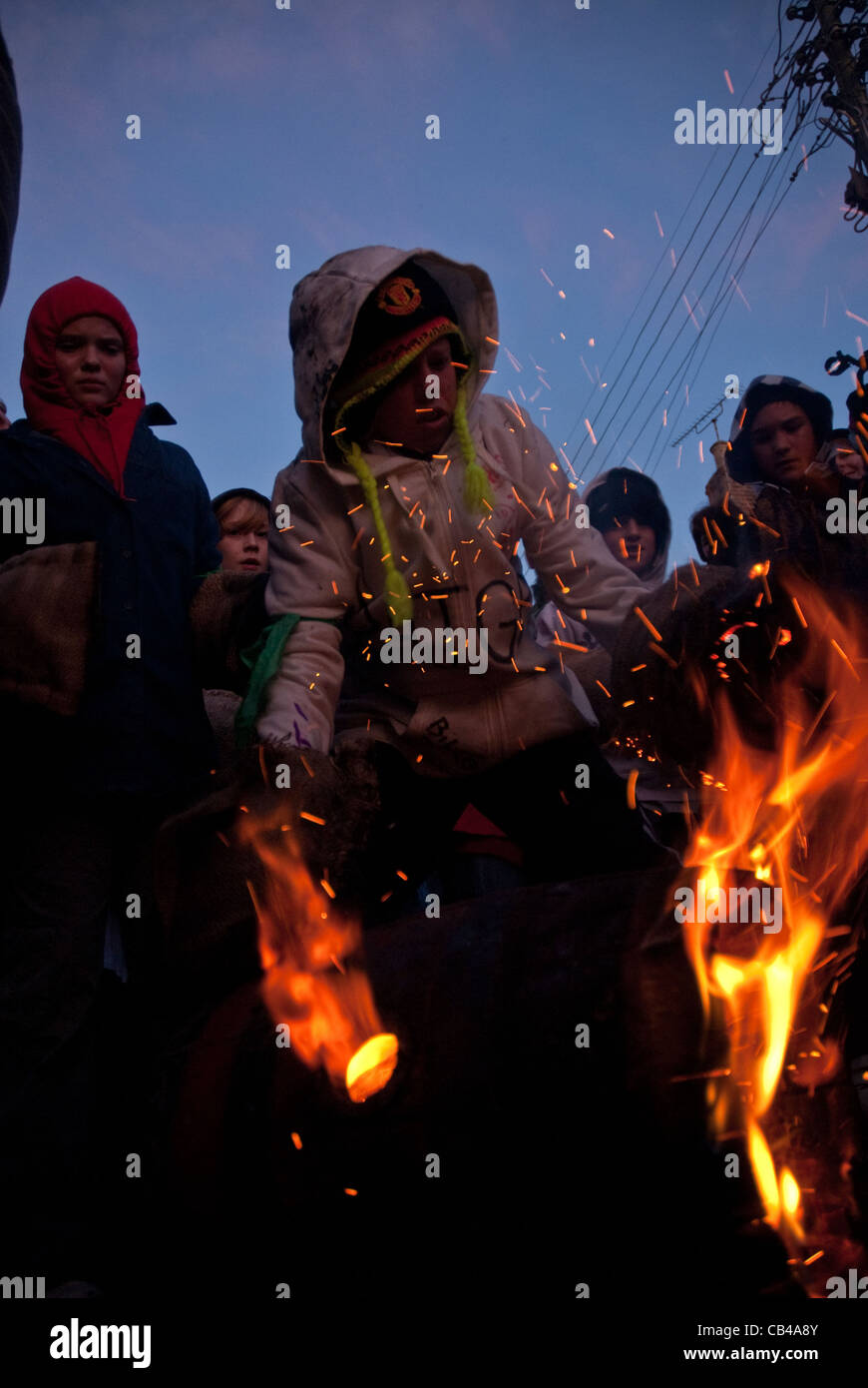 Eine junge Walze versucht, einem brennenden Teer Fass zum Jahresbeginn 2011 Tar Barrel des schon Karneval abholen. Stockfoto
