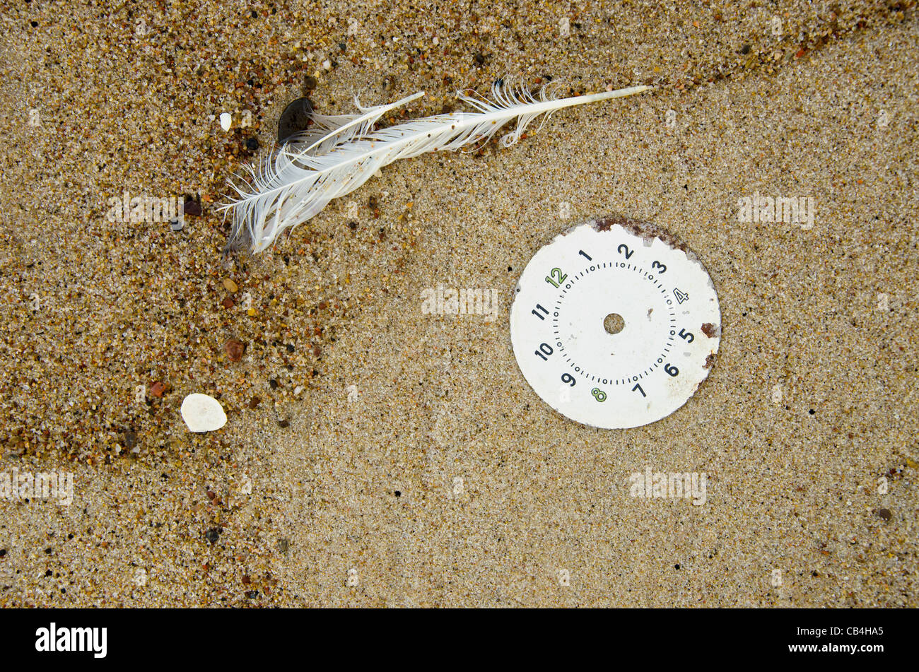 Retro-Ziffernblatt auf Strandsand und Feder Stockfoto