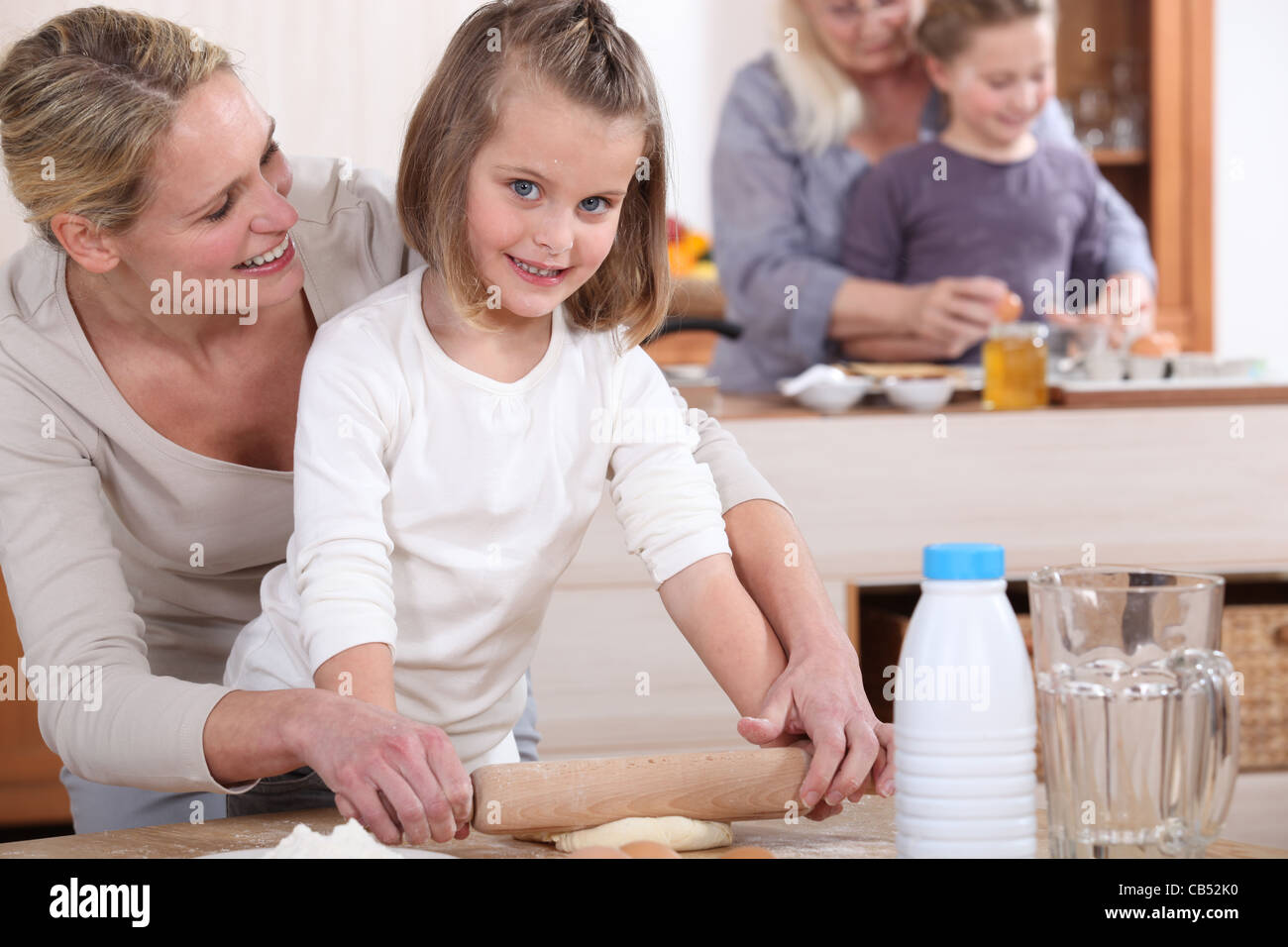 Kleine Mädchen und ihren Müttern, die Herstellung von Kuchen Stockfoto