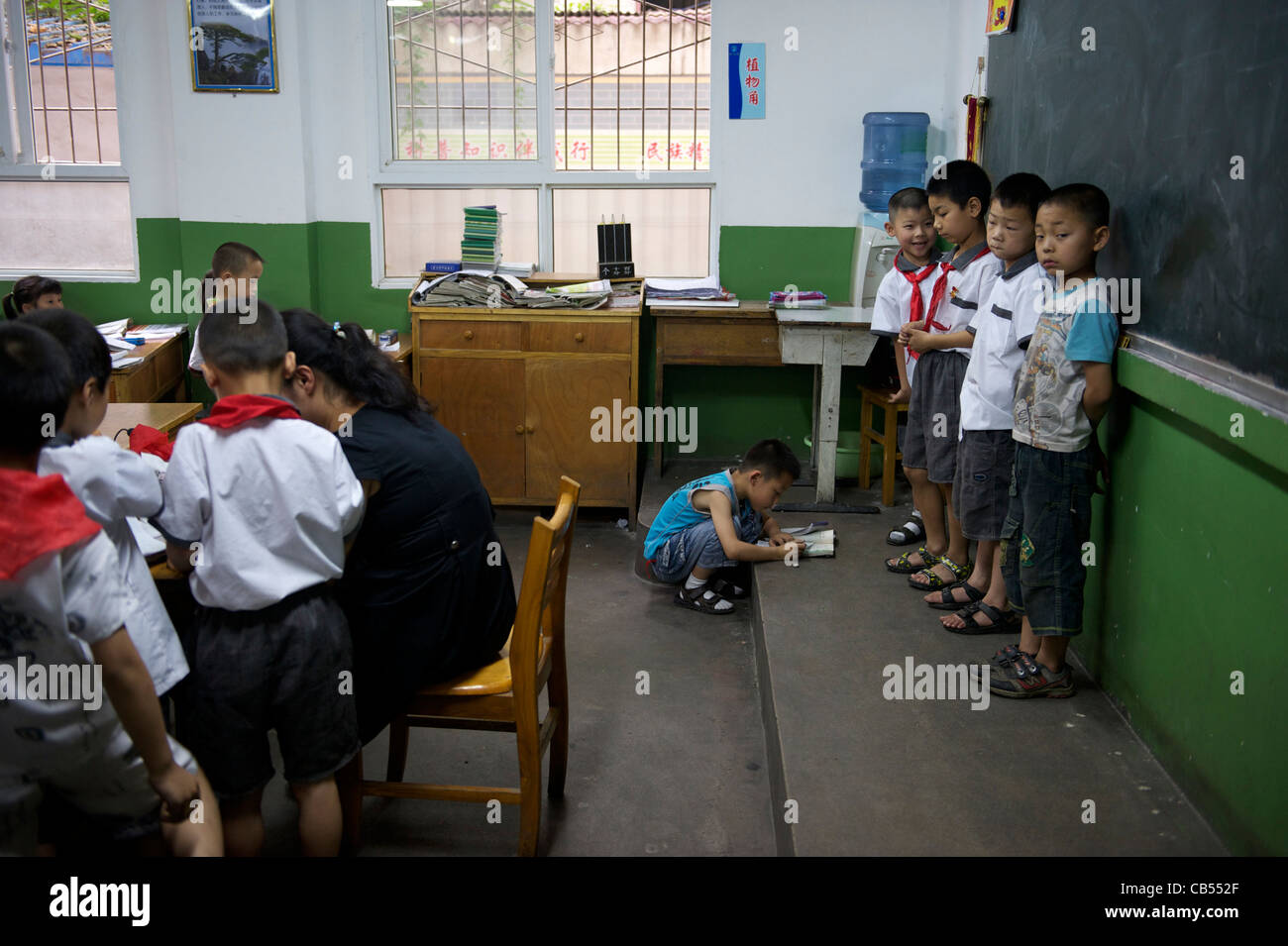 Lehrer macht 4 Schüler vor der Tafel in der Klasse als Strafe in einer Grundschule in Xian, China stehen. 2011 Stockfoto