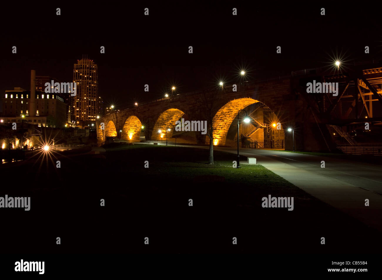 Stein-Bogen-Brücke in der Nacht unter Lichter und Stadt Ruinen in der Innenstadt von Minneapolis Minnesota Stockfoto