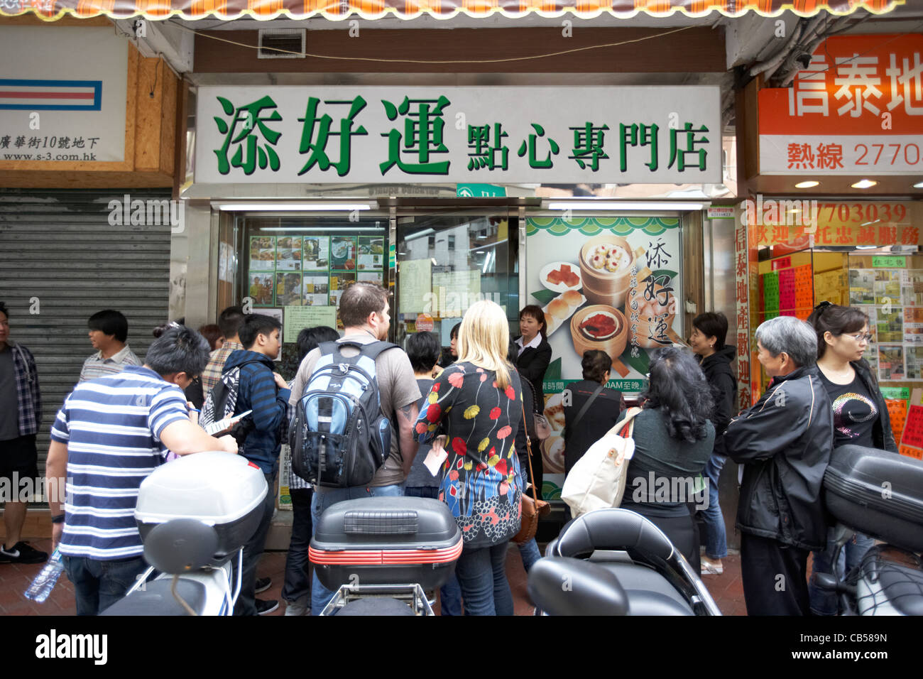 Menschen außerhalb der ursprünglichen dim sum Tim ho wan Michelin starred Restaurant warten in Mong Kok Bezirk Kowloon Hong Kong SAR Hongkong, China Stockfoto