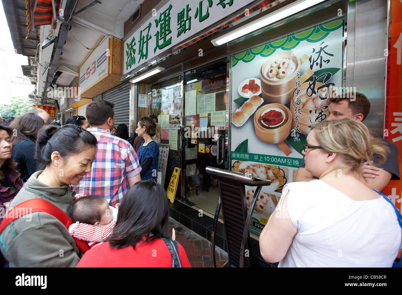 Die Menschen in der Warteschlange außerhalb der ehemaligen ein Dim Sum tim Ho wan mit einem Michelin-Stern ausgezeichnete Restaurant Lage in Mong Kok Bezirk Kowloon Hong Kong SAR Hongkong, China Stockfoto