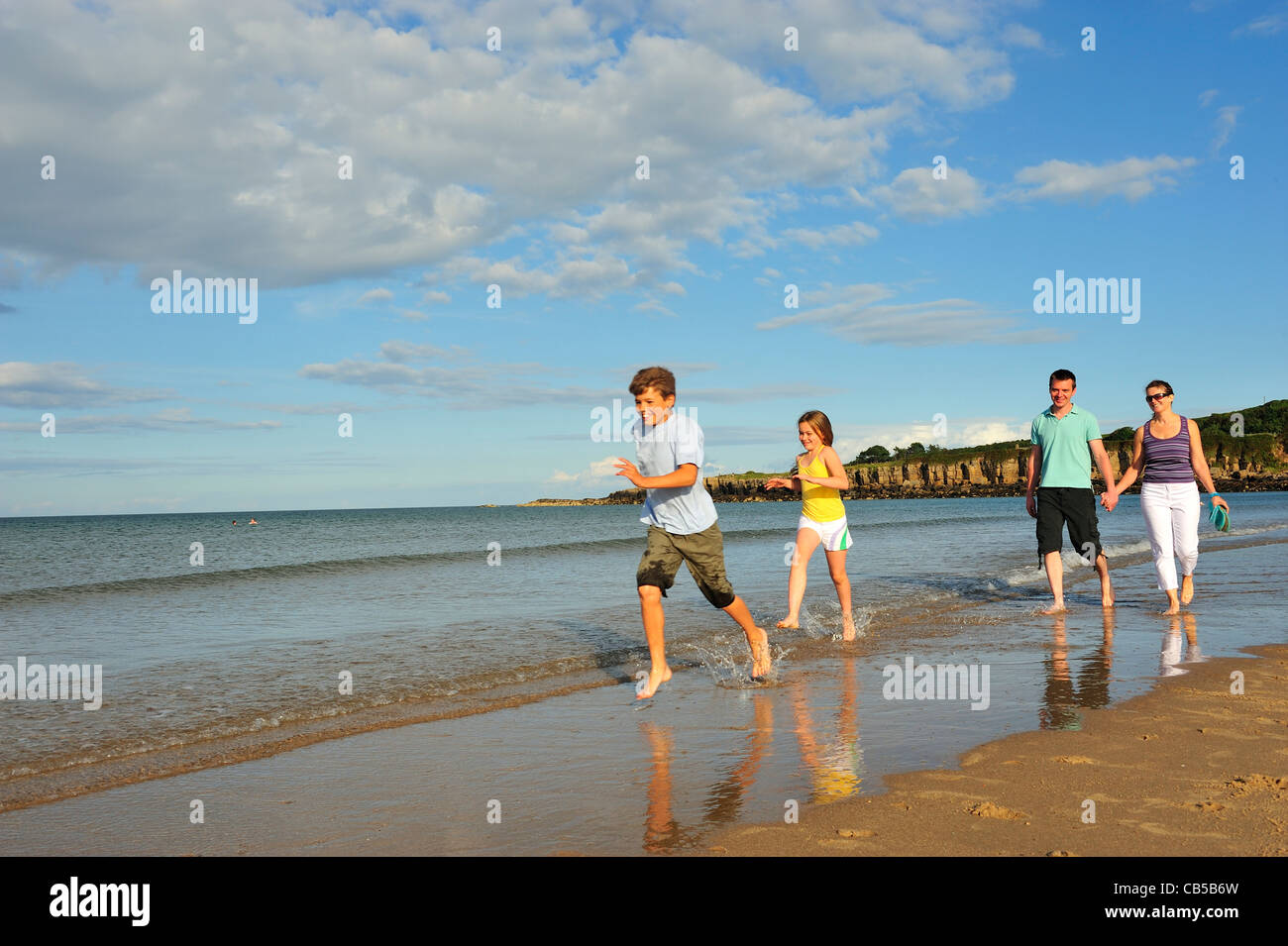 Familie am Strand entlang spazieren. Stockfoto