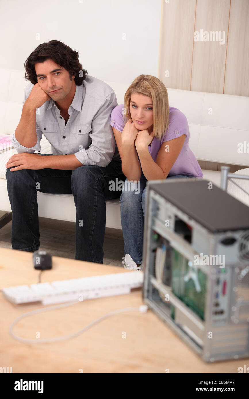 Paar saß vor der defekten computer Stockfoto