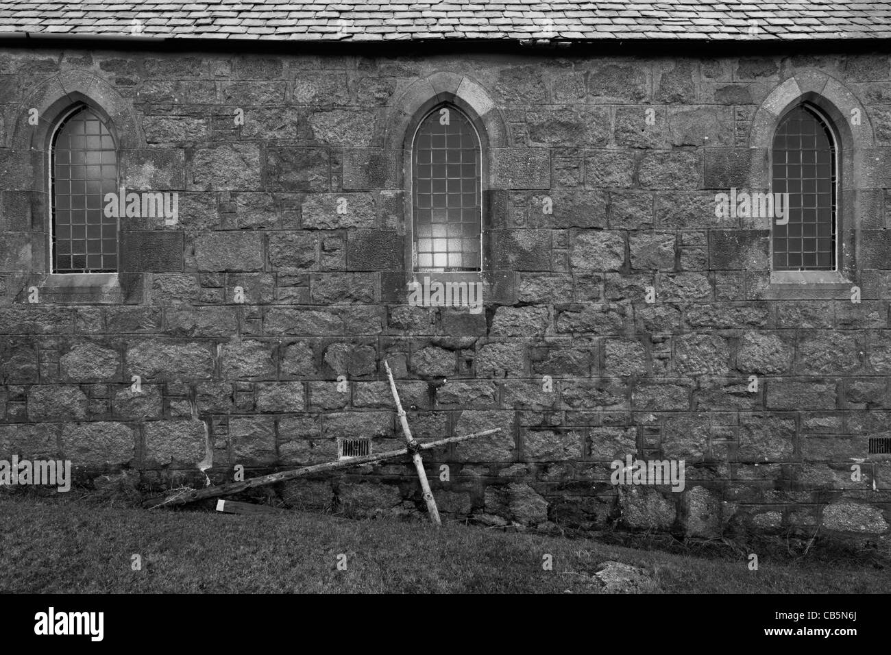 Kruzifix Kreuz Stütze gelehnt Außenwand der Kirche St Ernan, Fionnphort, Isle of Mull, Schottland. Stockfoto
