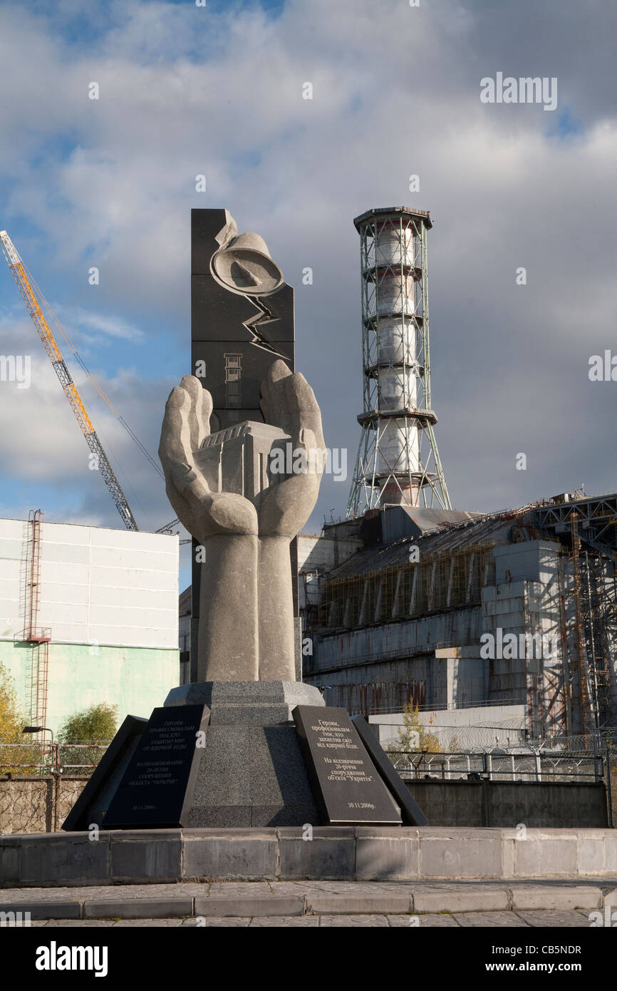 Denkmal für die Chernobyl Liquidatoren mit Reaktor Nummer 4 im Hintergrund, Kraftwerk Tschernobyl Ukraine Stockfoto