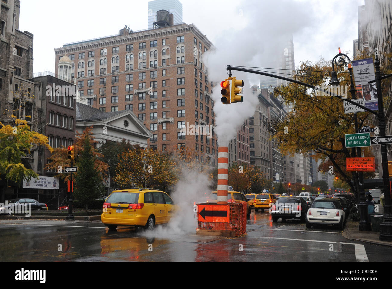 Dampf steigt aus einem Standrohr im Straßenverkehr an verregneten Tag Manhattan New York NYC USA Stockfoto