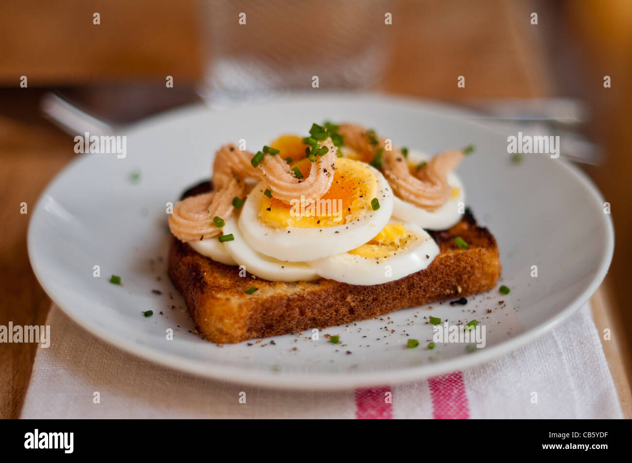 Klassische schwedische öffnen konfrontiert Sandwich aus geschnittenem gekochtem Ei garniert mit Kalles Kaviar und mit gehacktem Schnittlauch bestreut. Stockfoto