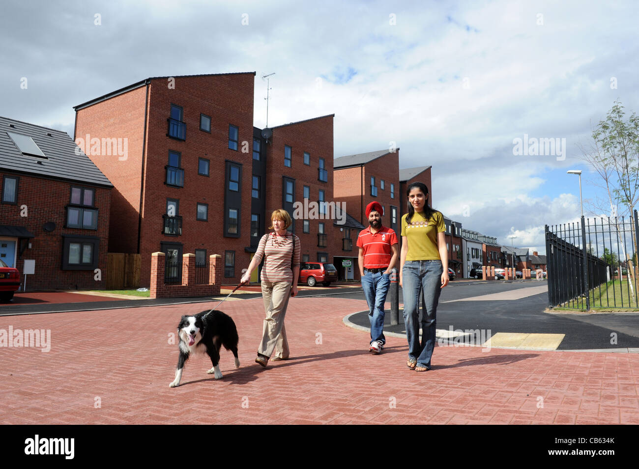 Frau zu Fuß Hund bauseits modernen Wohnens in Wolverhampton England Uk Stockfoto