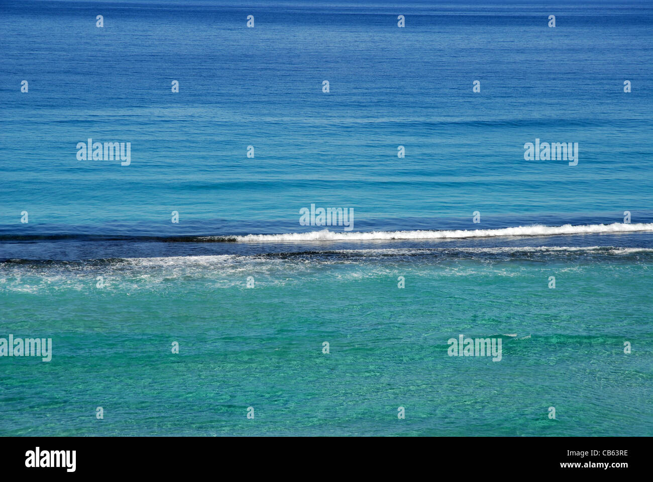ruhigen blauen Meer mit Wellen brechen sich am untergetauchten Felsen, Esperance, Western Australia, Australien Stockfoto