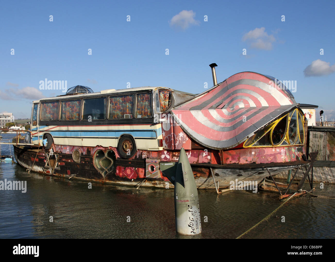 Eines der Hausboote auf dem Fluss Adur an Shoreham West Sussex, UK, mit einer umgedrehten Torpedo im Vordergrund bei Flut. Stockfoto