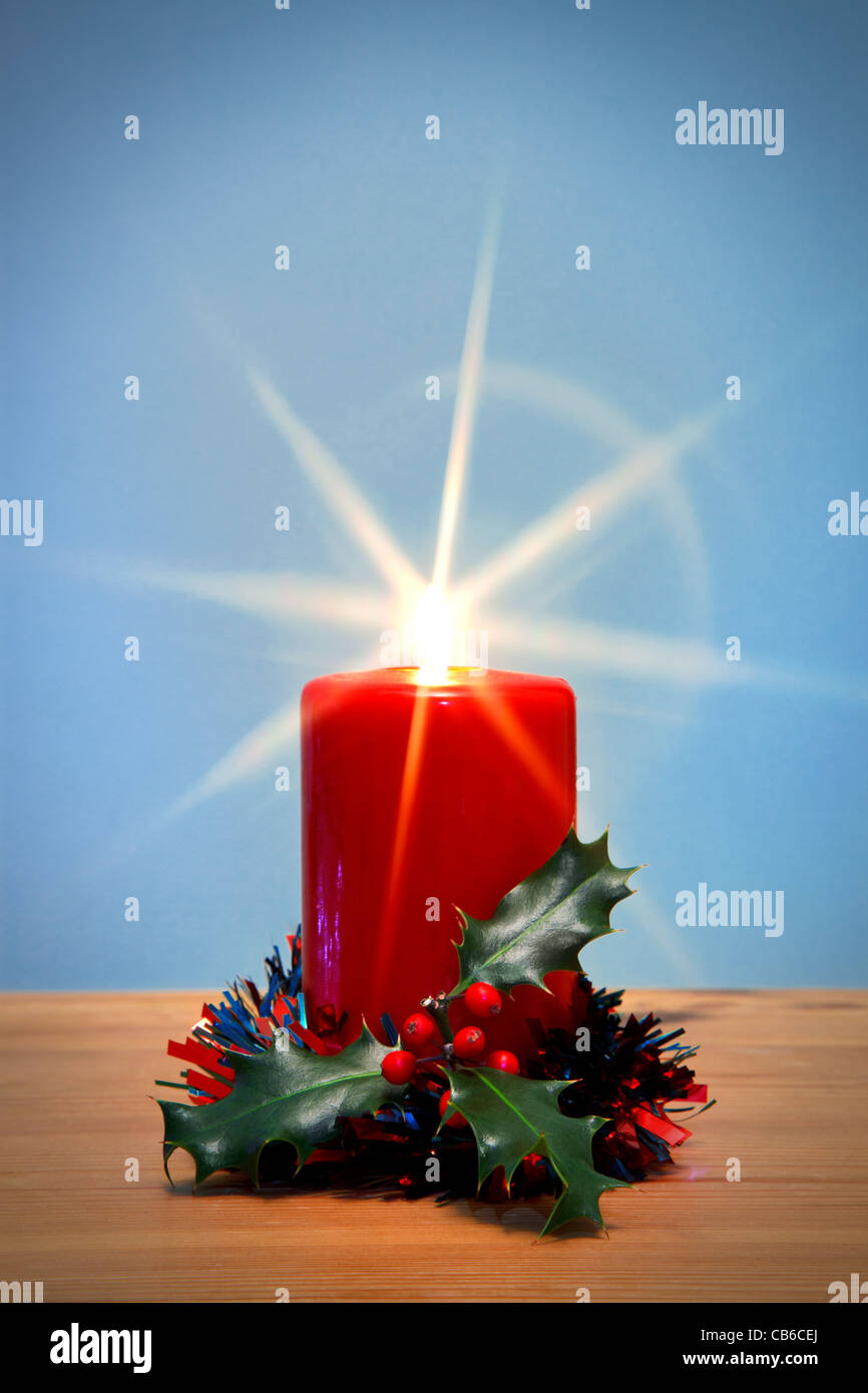 Foto von einem Weihnachtskerze und Holly mit Starburst, der Star aus der Flamme entstand in der Kamera mit Hilfe eines Filters. Stockfoto