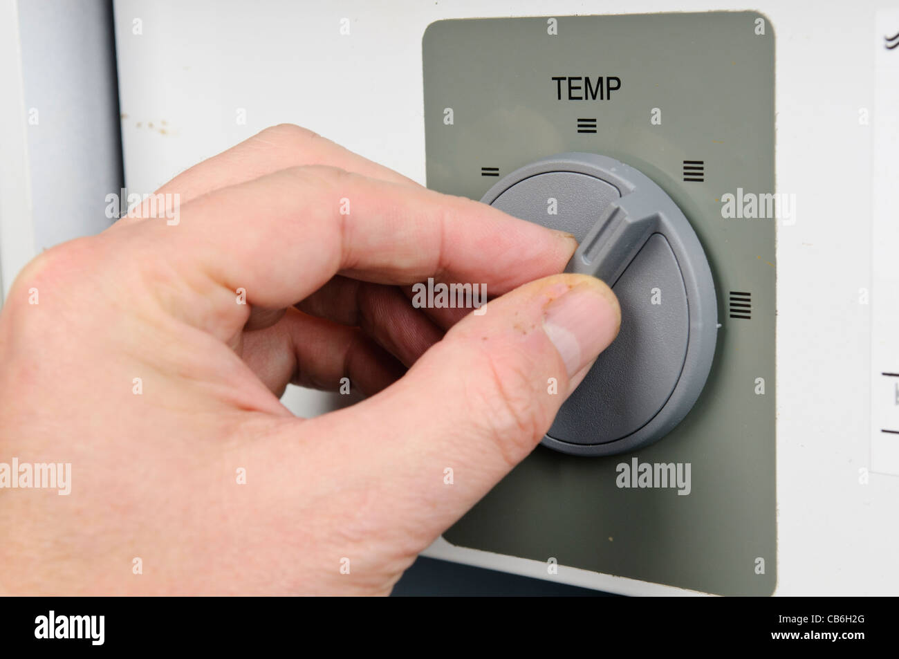 Man passt sich den Thermostat auf einem inländischen Kessel Stockfoto