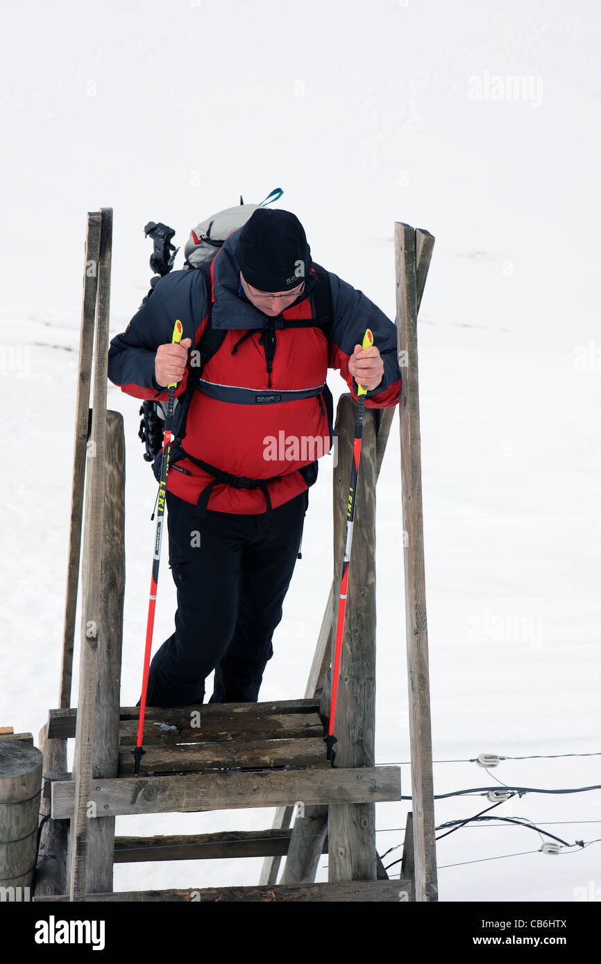 Walker ein Elektrozaun auf Meall Nan Tarmachan in Schottland einen Stil Überklettern Stockfoto