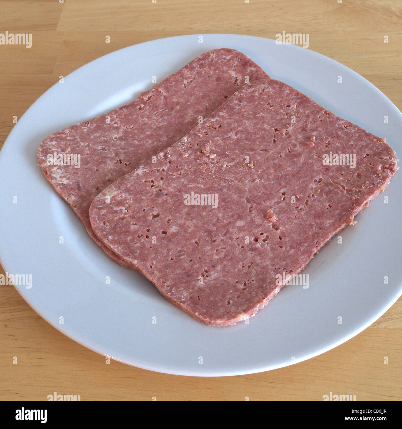 Scheiben von Corned Beef auf einem weißen Teller Stockfoto