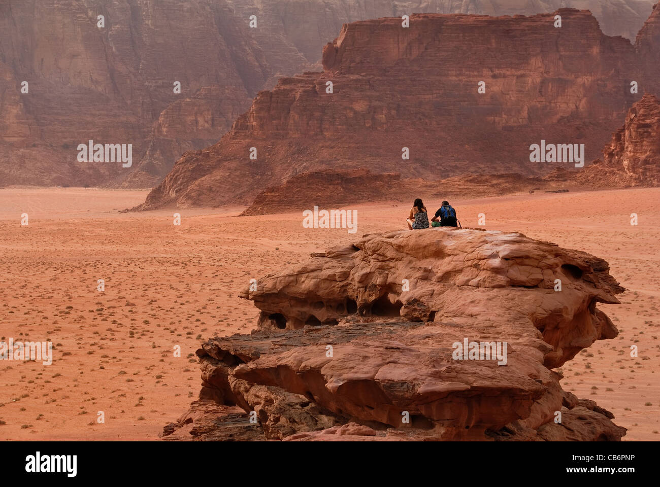 Ein paar sitzen an einem kleinen Aussichtspunkt in der Wadi rum Wüste in Jordanien. Stockfoto