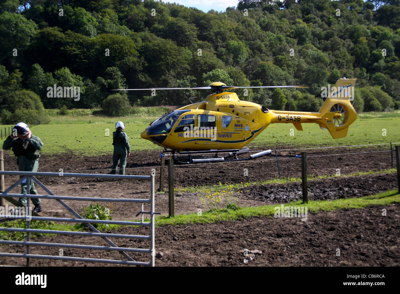 Schottischer Krankenwagen-Service Air Ambulance Helikopter behandelnden Vorfall im Feld laden Patienten auf Keilrahmen Stockfoto