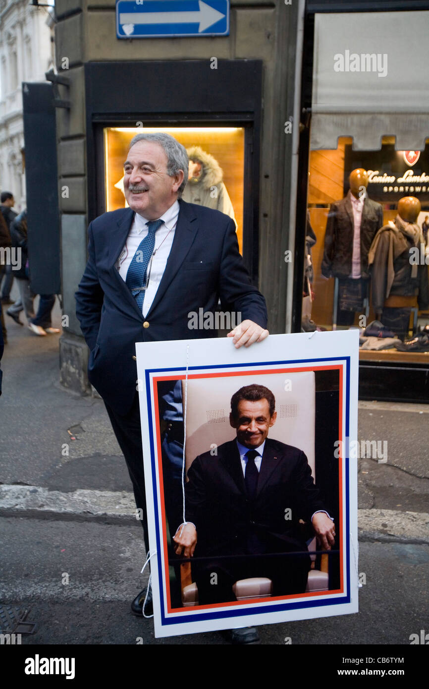Mann hält ein Bild des französischen Präsidenten Nicolas Sarkozy in der Straße von Rom, Italien Stockfoto