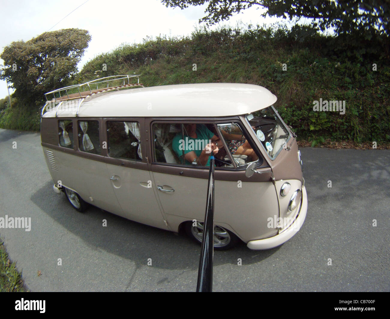 1966, senkte VW Split Screen Wohnmobil, fahren entlang der Straßen von Cornwall. Stockfoto